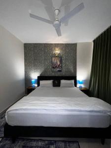 勒克瑙Panaromic Perch With Swimming Pool的一间卧室配有一张大床和两盏蓝色灯