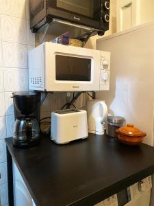 瓦伦西亚Valencia Well Located Shared Apartment的厨房柜台配有微波炉和咖啡壶