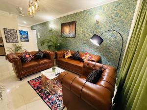 勒克瑙Panaromic Perch With Swimming Pool的客厅配有棕色皮沙发和桌子