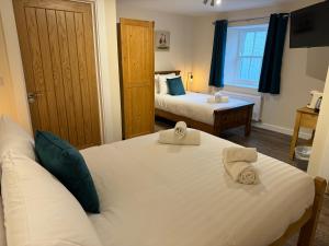 莫珀斯The Beresford Arms的酒店客房设有两张床和窗户。