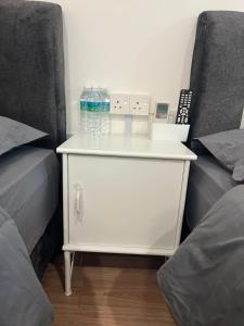 太平KIWI INN的一张白色梳妆台,配有2张床边的瓶装水