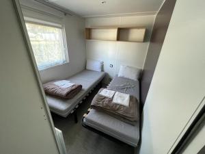 乌尔加特Grand Mobil Home的小房间设有两张床和窗户