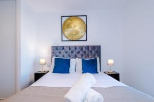伯明翰Axium Suite- Modern 2 bed in Birmingham City Centre- Perfect for Business, Family and Leisure Stays的一间卧室配有一张带蓝色枕头的大床