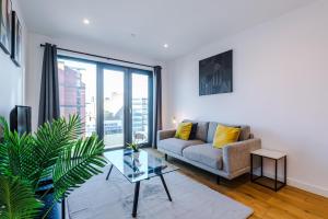 伯明翰Axium Suite- Modern 2 bed in Birmingham City Centre- Perfect for Business, Family and Leisure Stays的带沙发和玻璃桌的客厅