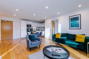 伯明翰Sterling Suite - Modern 2 Bedroom Apartment in Birmingham City Centre - Perfect for Family, Business and Leisure Stays by Dreamluxe的客厅配有绿色沙发和桌子