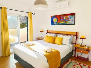 莫尼兹港Porto Moniz Villa的一间卧室配有一张带黄色枕头的大床