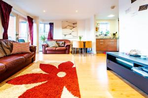 伦敦1 bedroom stylish apartment in zone 2 close to center - whole apartment的客厅配有沙发和红花地毯