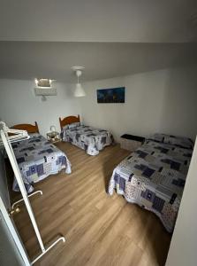 桑卢卡尔-德巴拉梅达Casa Mari的客房设有三张床,铺有木地板。