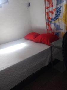 奥林达Casa Completa的一间卧室配有一张带两个红色枕头的床