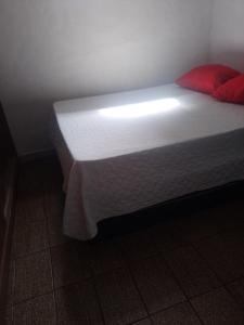 奥林达Casa Completa的一张位于房间的床,配有白色床垫和红色枕头