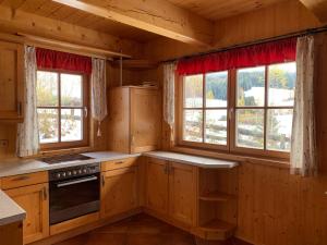 穆劳Pichelhütte的小屋内的厨房设有木制橱柜和窗户