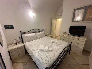 阿拉西奥[2 passi dal mare di Alassio] Ampio trilocale的一间卧室配有带毛巾的床和电视。