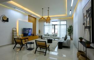 富查伊拉Al Bandar Luxury Villa with 5BR with private pool - Al Dana Island Fujairah by OCEANVIEW HOLIDAY HOMES的客厅配有沙发和桌椅