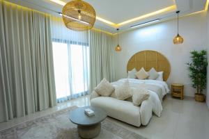富查伊拉Al Bandar Luxury Villa with 5BHK with private pool的一间卧室配有一张大床和一张沙发