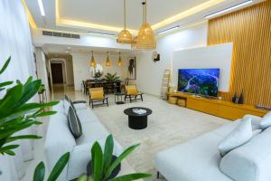 富查伊拉Al Bandar Luxury Villa with 5BR with private pool - Al Dana Island Fujairah by OCEANVIEW HOLIDAY HOMES的客厅配有2张白色沙发和电视