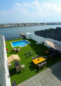 富查伊拉Al Bandar Luxury Villa with 5BHK with private pool的一个带桌椅的阳台和一个游泳池