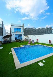 富查伊拉Al Bandar Luxury Villa with 5BHK with private pool的庭院中带游泳池的房子