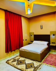 伊尔富德COMPLEXE L'OASIS的一间卧室配有红色窗帘和地毯的床