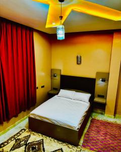 伊尔富德COMPLEXE L'OASIS的一间卧室配有床和红色窗帘