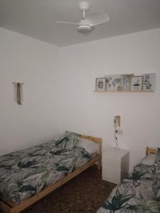 圭哈尔谢拉La fuente的一间卧室配有一张床和一个带灯的床头柜