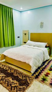 伊尔富德COMPLEXE L'OASIS的一间卧室配有一张带绿帘的大床
