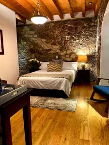 雷亚尔卡托尔塞HOTEL MINA REAL的一间卧室设有一张床和石墙