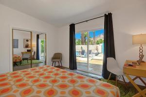 棕榈泉Shelby Sands的一间卧室配有一张床、一张书桌和一个窗户。