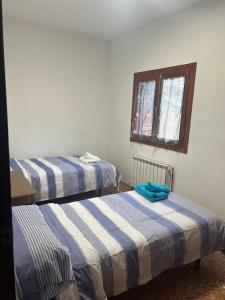 AliagaApartamento JUMIDOSIV的带窗户的客房内设有两张单人床。