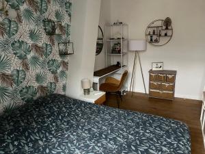 里尔Chambre privée Place aux oignons的一间卧室配有一张带绿色图案墙壁的床