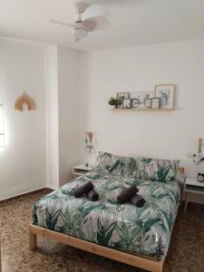 圭哈尔谢拉La fuente的一间卧室配有一张带绿叶床罩的床。