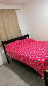 萨利纳斯Bougainville salinas beach的一张床上的红色棉被放在房间里