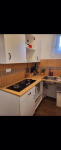 巴拉通雷勒Olivér Apartmanház的厨房配有白色橱柜和炉灶烤箱。