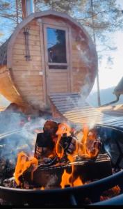 Šentvid pri StičniRomantic cabin with hot/cold tub and finnish sauna的烤架上的火,背景是房子