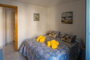 格拉纳达Casa Asia的一间卧室配有一张带黄色枕头的床