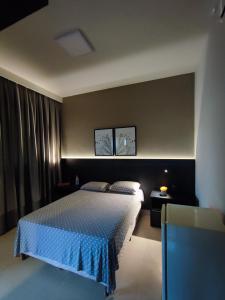 乌贝拉巴Suíte Alto Padrão的一间卧室配有一张带蓝色床罩的床