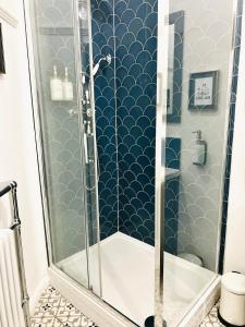 霍姆弗斯Nine Cooper Lane, Holmfirth的浴室设有蓝色和白色瓷砖淋浴。