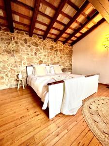 普拉加德阿罗B&B La Vista Brava的一间卧室设有一张床和石墙