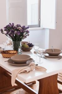 阿尔科巴萨Casa Quintal da Aldeia的一张桌子,上面有盘子和玻璃杯,花瓶