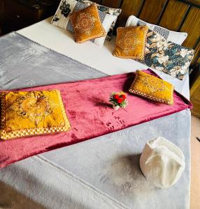 伊斯兰堡Luxury Family的两张带彩色枕头和红色毯子的床