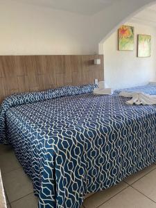 Monte GordoHotel Torre Molino的一间卧室配有一张带蓝色和白色棉被的床