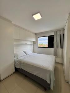 帕尔马斯excelente localização, td climatizado, 2/4 e piscina的一间卧室设有一张大床和一个窗户。