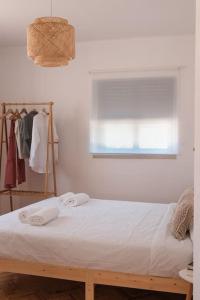 阿尔科巴萨Casa Quintal da Aldeia的一间卧室配有床,窗户配有毛巾