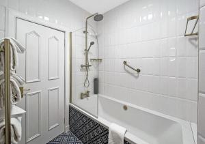 皮特洛赫里艾瑟尔宫酒店的白色的浴室设有浴缸和淋浴。