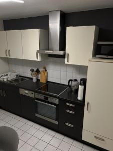 LathenFerienwohnung 24 Unten Rechts 3 Zimmer的厨房配有黑色柜台和白色冰箱。