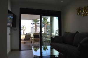 阿尔比尔Albir Beach & Sea Apt的带沙发和玻璃桌的客厅