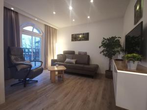 奥斯赛拜-屈隆斯博恩Apartmenthaus Atlantik的客厅配有沙发和椅子