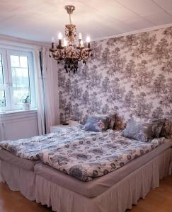 韦纳穆荷拉乐浓酒店的配有吊灯的卧室内的一张大床