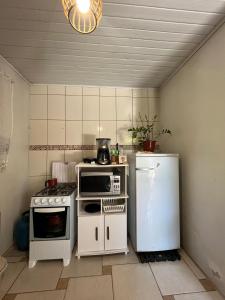 布卢梅瑙Casa com suíte的小厨房配有冰箱和微波炉。