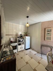 布卢梅瑙Casa com suíte的厨房配有炉灶和冰箱。