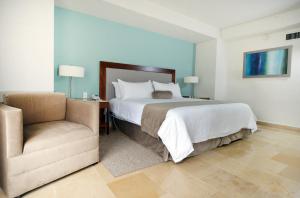贾拉普HB哈拉帕酒店的一间卧室配有一张大床和一把椅子